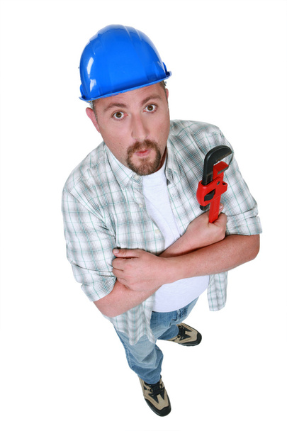 Grumpy plumber posing with wrench - 写真・画像
