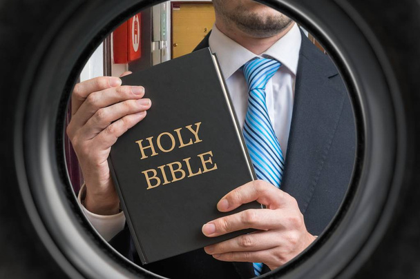 Il testimone di Geova sta mostrando la Bibbia dietro la porta. Vista dallo spioncino
 - Foto, immagini