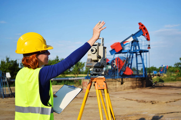 A geodetic engineer on duty on petroleum field - Photo, Image