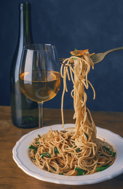 Spaghettis aux tomates et une bouteille de vin sur une table en bois. Rétro tonification
. - Photo, image