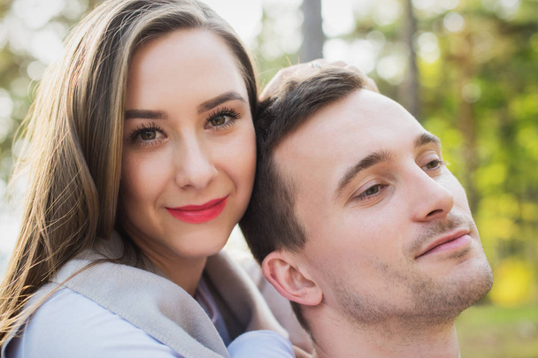 Happy young couple in love hugging. Park outdoors date. Loving couple looking at camera portrait. - Фото, изображение
