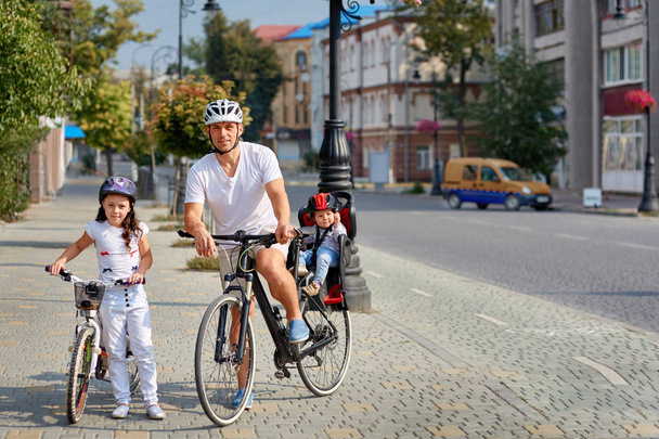 Cheerful family biking in park - Foto, Imagen
