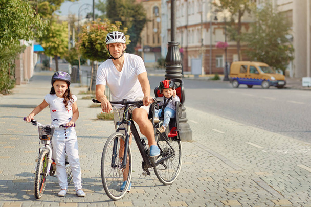 Cheerful family biking in park - Foto, Imagen