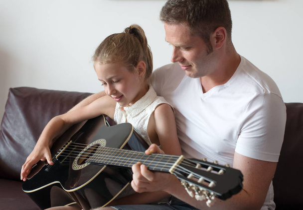 Dad teaches daughter to play guitar. - Photo, Image