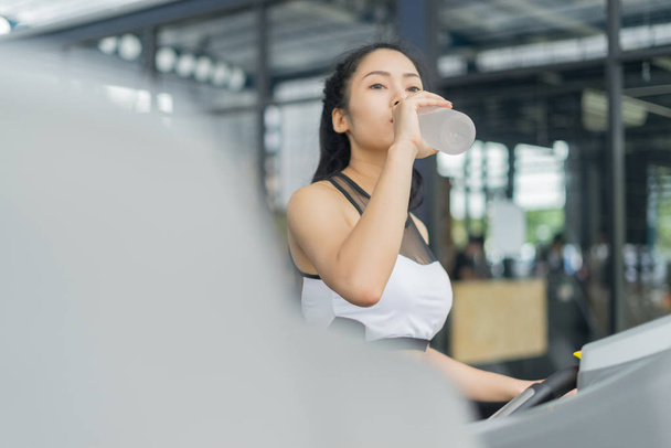 Fitness woman in training drinking water after exercises in gym, sport concept - Zdjęcie, obraz