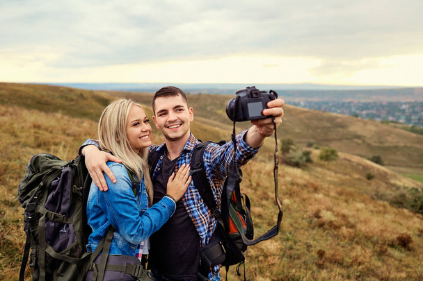 Пара путешественников фотографируются на камеру в природе
. - Фото, изображение