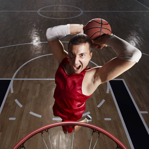 Jugador de baloncesto hace slam dunk
 - Foto, Imagen