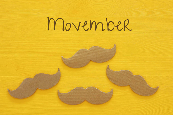 Movember cancer awareness event concept over wooden background. Top view - Φωτογραφία, εικόνα