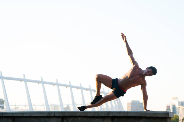 Sportsman doing arm balance on roof - Zdjęcie, obraz