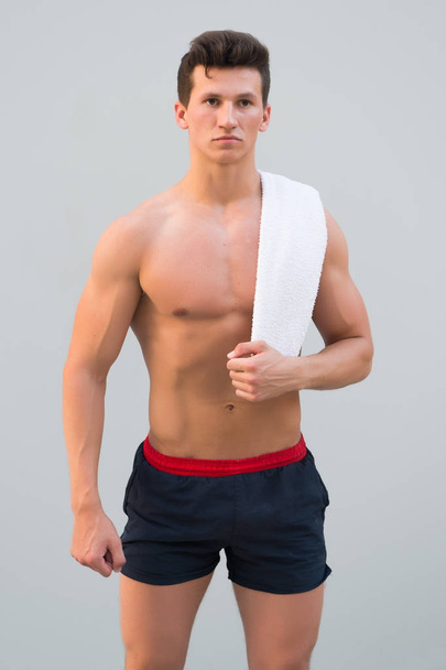 Man with towel on neck on grey background - Foto, afbeelding