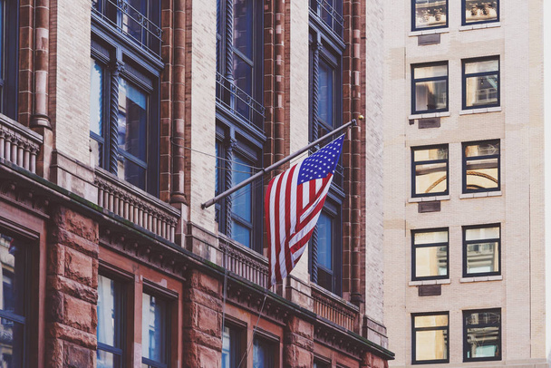 マンハッタンのブロードウェイに建物から手を振っているアメリカの国旗 - 写真・画像