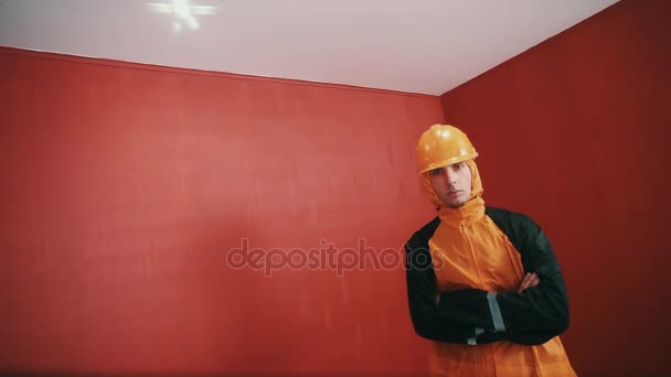 ビルダーで武装した赤クロス ジャケットとオレンジ ハード帽子の男を部屋に、ラップ - 映像、動画