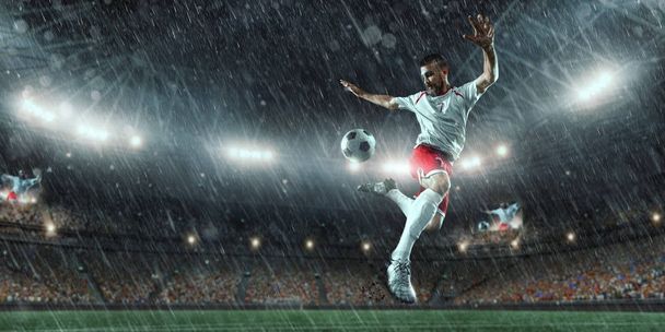Ποδοσφαιριστής εκτελεί ένα παιχνίδι δράσης σε ένα επαγγελματικό γήπεδο - Φωτογραφία, εικόνα