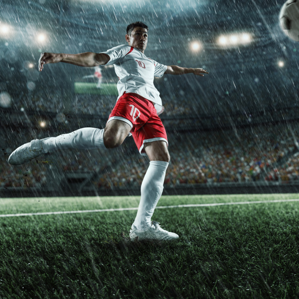 Ποδοσφαιριστής εκτελεί ένα παιχνίδι δράσης σε ένα επαγγελματικό γήπεδο - Φωτογραφία, εικόνα