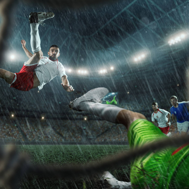 Ποδοσφαιριστές εκτελεί ένα παιχνίδι δράσης σε ένα επαγγελματικό γήπεδο. Δείτε μέσα από το ποδόσφαιρο γκολ - Φωτογραφία, εικόνα