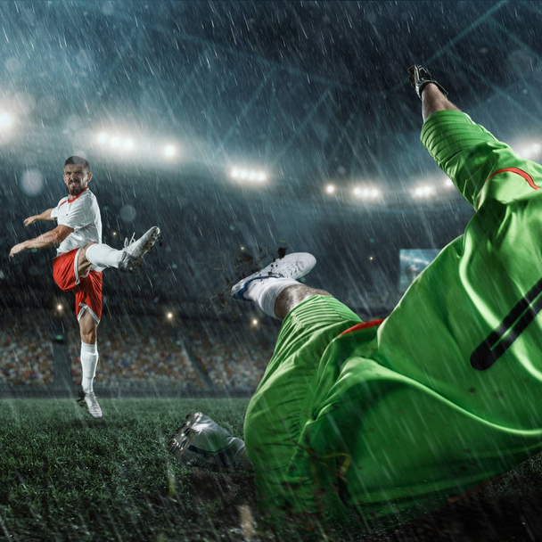 Jugadores de fútbol realizan un juego de acción en un estadio lluvioso profesional
 - Foto, Imagen