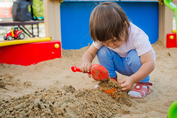 niña jugando en una caja de arena
 - Foto, Imagen