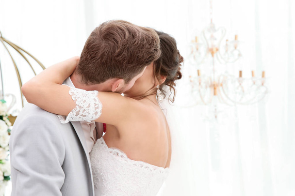 Happy beautiful couple kissing on wedding day, indoors - Foto, Bild