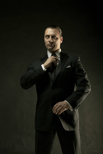 The attractive man in black suit on dark background - 写真・画像