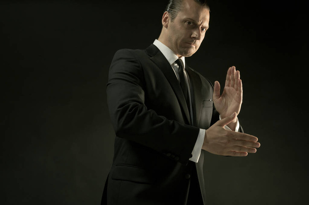 The attractive man in black suit on dark background - Foto, Imagen