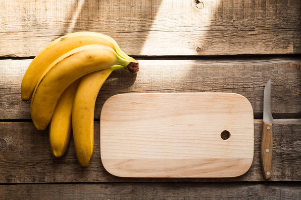 snijplank, fruit, koken, voedsel, keukengerei, bananen, houten achtergrond - Foto, afbeelding