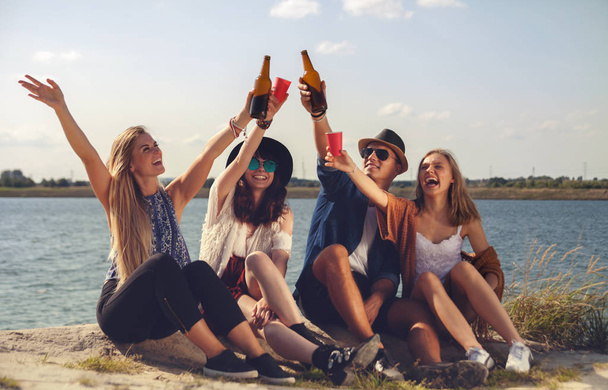 Friends having fun and drinking at the beach, positive mood - Photo, image