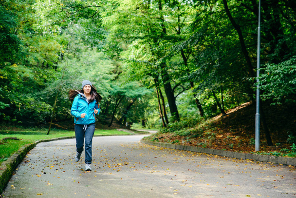молода красива жінка біжить потай в парку
 - Фото, зображення