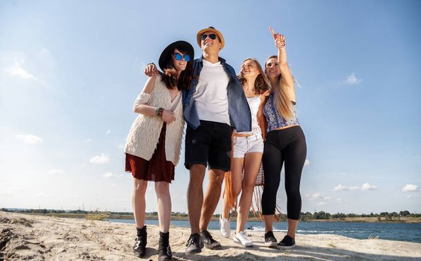Group of happy friends walking on beach, fashion styled - Foto, Imagen
