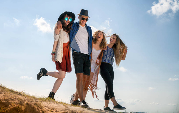 Group of happy friends walking on beach, fashion styled - Foto, afbeelding