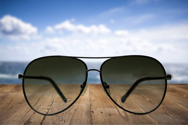 Zwarte mode zonnebril op zwembad achtergrond  - Foto, afbeelding