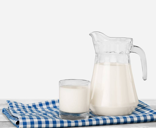 Glass of milk and jug on  table  - Photo, image