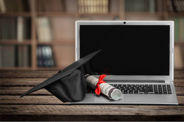 Laptop and diploma scroll and graduation hat  - Zdjęcie, obraz