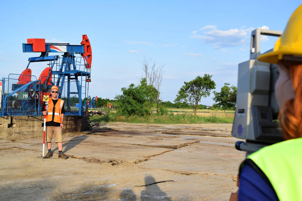 Two geodets at work on an oil well - Photo, Image