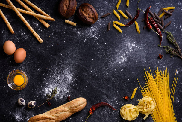Italian cuisine ingredients - pasta spaghetti on dark background - Fotografie, Obrázek