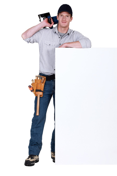 Carpenter stood by blank message board with circular-saw - Foto, immagini