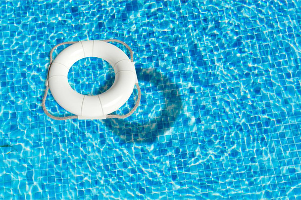 Кольцо жизни, плавающее на солнечной голубой воде
 - Фото, изображение