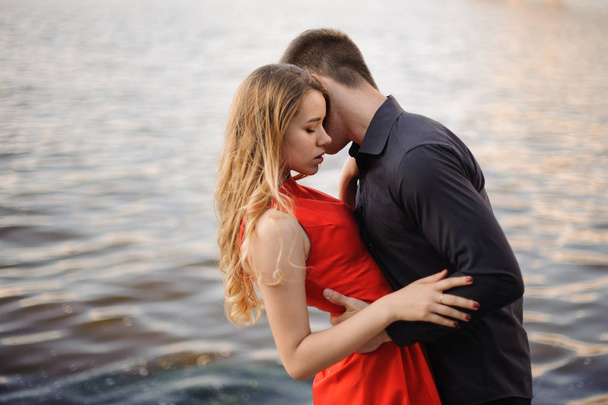 Beautiful loving couple n the background of water - Foto, Imagen