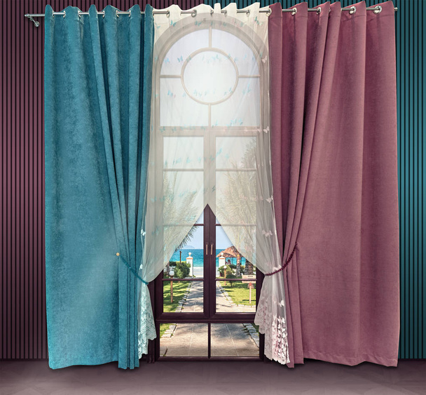 Design d'intérieur aux couleurs bleu et rose. Porte haute voûtée avec accès à la mer et rideaux de velours droits sur les oeillets
. - Photo, image