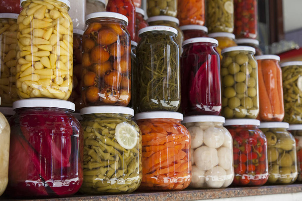 Closeup of canned vegetables in glass jars on the table in the m - Foto, Bild