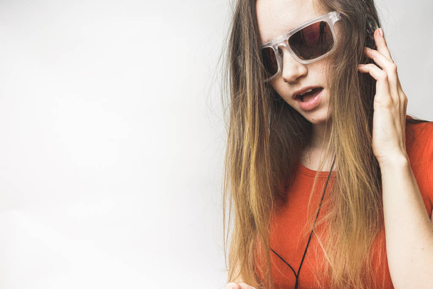 Happy young woman listening, long hair, cool sunglasses. Woman in headphones and glasses - Foto, immagini