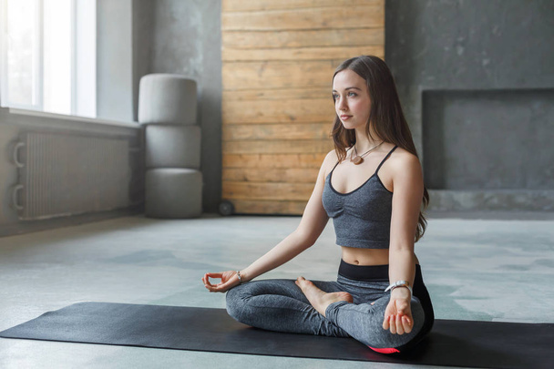 junge Frau im Yoga-Kurs, entspannte Meditationspose - Foto, Bild