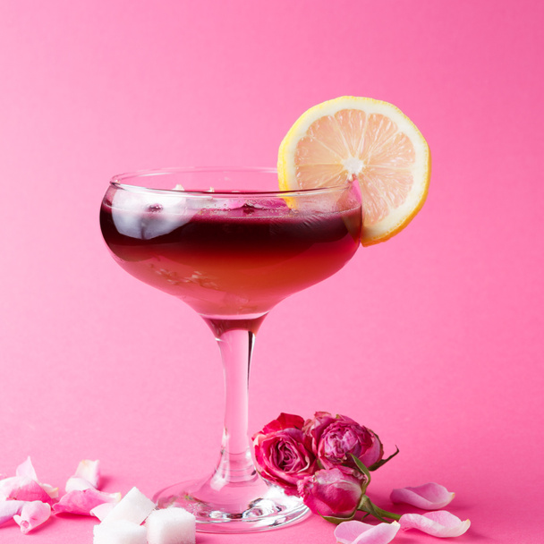 Τριαντάφυλλο κοκτέιλ στο ποτήρι σαμπάνιας σε ροζ φόντο - Φωτογραφία, εικόνα