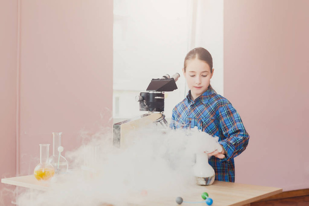 Chica haciendo experimento con nitrógeno en laboratorio
 - Foto, Imagen