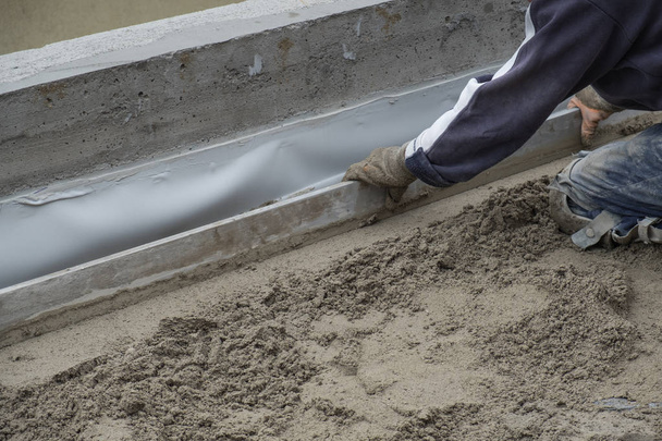 Operaio edile livellamento del pavimento di cemento
 - Foto, immagini