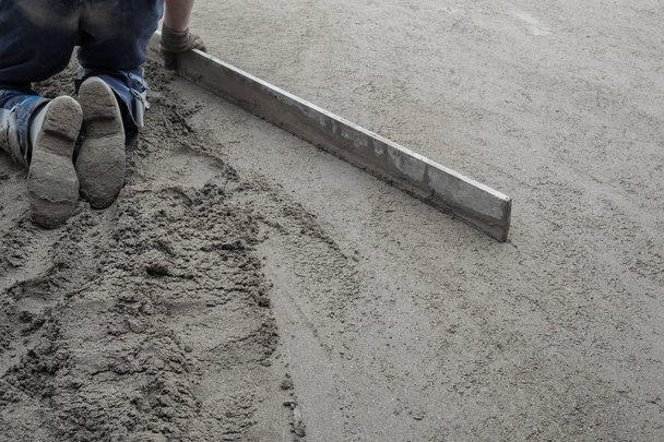 Trabajadores de la construcción nivelando el piso de hormigón
 - Foto, imagen