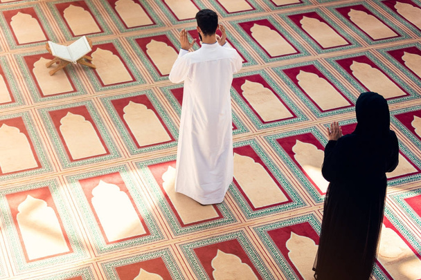 vista dall'alto dell'uomo e della donna musulmani che pregano in moschea
 - Foto, immagini