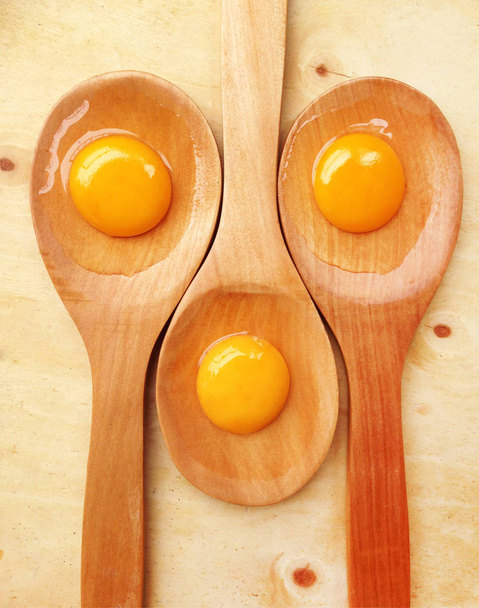 York eggs on wooden ladle on wooden background - Photo, Image