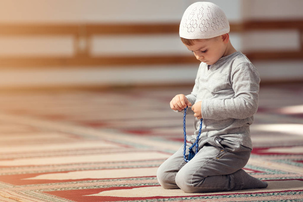 The Muslim child prays in the mosque, the little boy prays to God, Peace and love in the holy month of Ramadan. - Valokuva, kuva