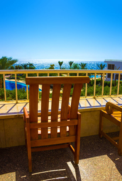 открытая терраса ресторана с видом на море и пальмы
 - Фото, изображение