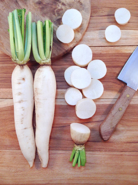 White daikon radish with sliced pieces on wooden table - Photo, Image